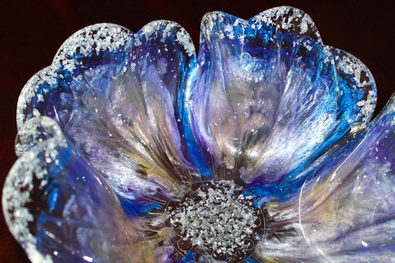 May include: A blue and purple resin flower bowl with silver glitter accents. The bowl is shaped like a flower with multiple petals.