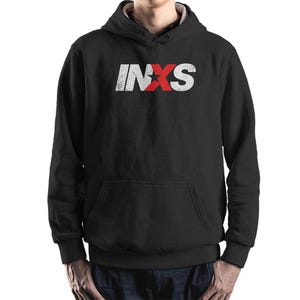 May include: Black hooded sweatshirt with a front pocket and the band name "INXS" printed across the chest in distressed white and red lettering. The hoodie has a drawstring and a relaxed fit.