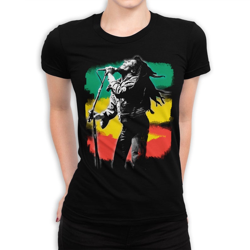 May include: Black t-shirt with a white silhouette of a singer holding a microphone in front of a green, yellow, and red background.