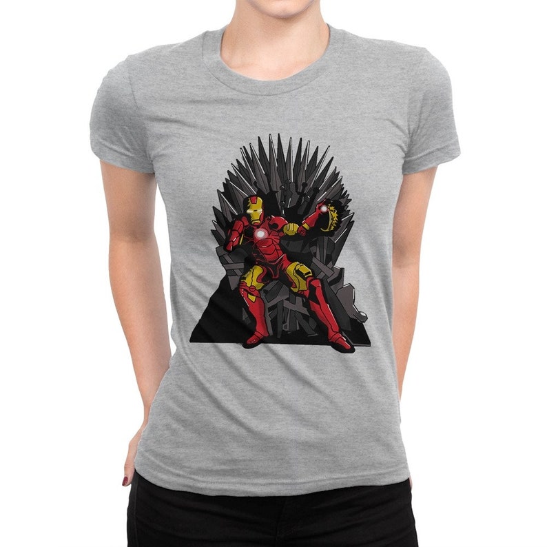 May include: A gray t-shirt with a graphic of Iron Man sitting on the Iron Throne from Game of Thrones. The Iron Throne is made of swords and Iron Man is holding his repulsor in his right hand.