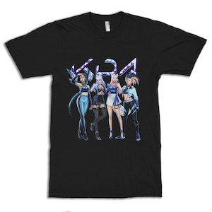 Könnte beinhalten: Schwarzes T-Shirt mit einem Grafikdruck von vier weiblichen Charakteren aus dem Videospiel League of Legends. Die Charaktere sind in farbenfrohen Outfits gekleidet und in einer dynamischen Gruppe posiert. Das Wort "K/DA" ist in großen, stilisierten Buchstaben über den Charakteren geschrieben.