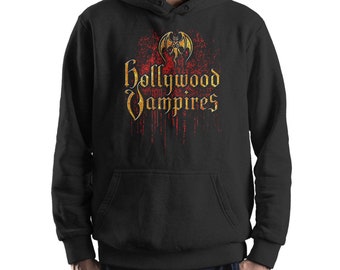 Könnte beinhalten: Schwarzer Kapuzenpullover mit einem grafischen Aufdruck einer Fledermaus und dem Text "Hollywood Vampires" in goldenen Buchstaben mit roter, tropfender Farbe.