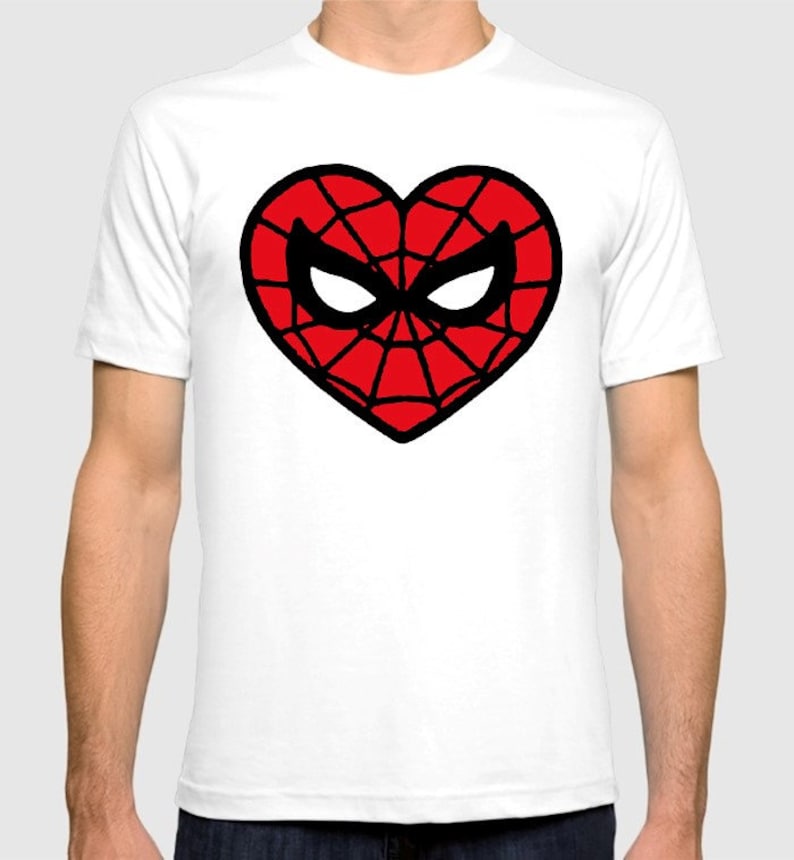 Puede incluir: Camiseta blanca con un dise&ntilde;o en forma de coraz&oacute;n rojo con un contorno negro de la m&aacute;scara y el patr&oacute;n de telara&ntilde;a de Spider-Man.