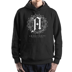 Puede incluir: Sudadera con capucha negra con un gráfico blanco de una letra 'A' estilizada dentro de un diseño de mandala. El texto 'ARCHITECTS' y 'Lost Forever If Lost Together' está impreso debajo del gráfico.