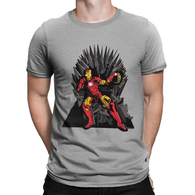 May include: A gray t-shirt with a graphic of Iron Man sitting on the Iron Throne from Game of Thrones. The Iron Throne is made of swords and Iron Man is holding the Infinity Gauntlet.