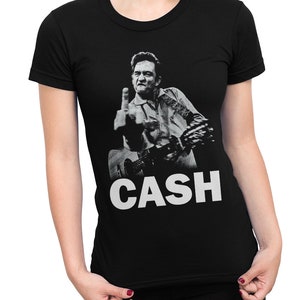Puede incluir: Camiseta negra con una foto en blanco y negro de Johnny Cash haciendo el dedo medio mientras toca la guitarra. El texto "CASH" est&aacute; impreso en blanco debajo de la foto.