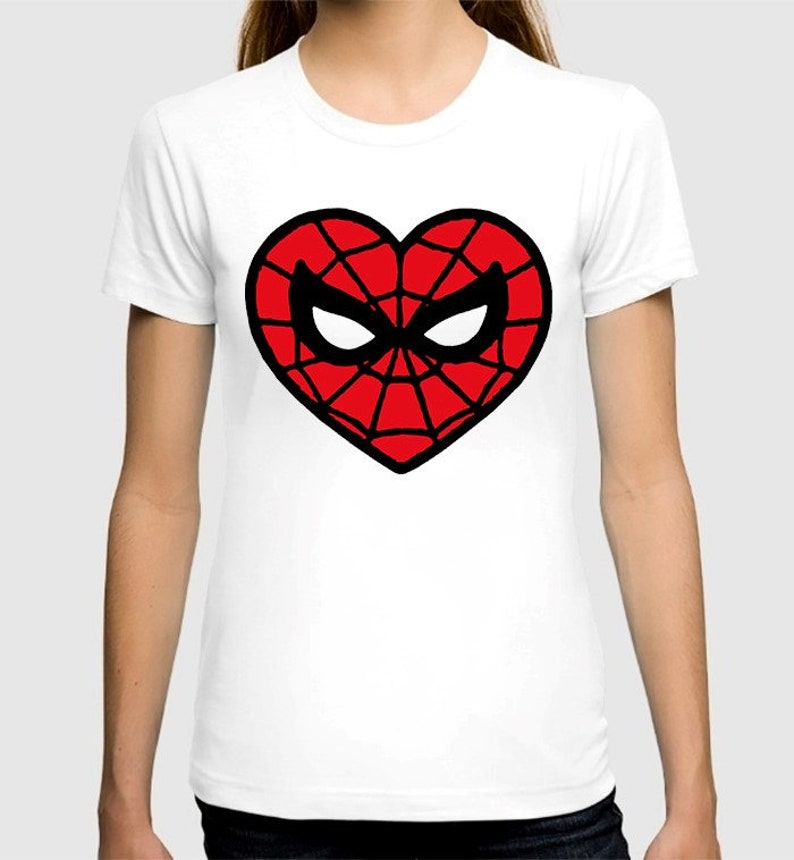 Puede incluir: Camiseta blanca con un dise&ntilde;o en forma de coraz&oacute;n rojo y negro con una m&aacute;scara de Spider-Man estilizada.