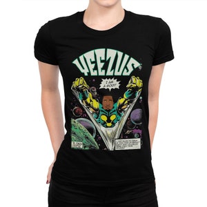 May include: Black t-shirt with a comic book style graphic of a man in a green and gold suit flying through space. The text "YEEZUS" is at the top of the graphic and "I AM A GOD!" is in a speech bubble. The text "I can't seem to explain my past what am I supposed to do? I'm just a n**** I'm sellin' this shit I'm sellin' this shit I'm sellin' this shit" is at the bottom of the graphic.