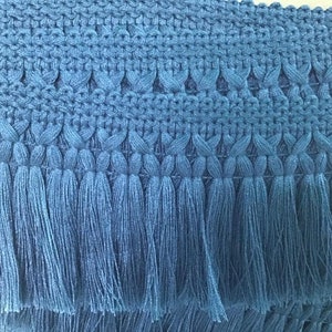 May include: Blue tassel trim with a woven design. The trim has a fringe of tassels that are about 1 inch long.