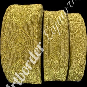 Puede incluir: Tres piezas de adorno de color dorado con un patrón geométrico. El adorno está tejido y tiene un brillo sutil.