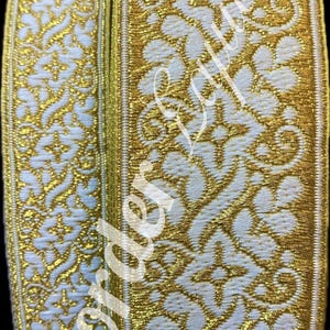 Puede incluir: Dos rollos de ribete blanco y dorado con un patrón floral. El ribete está tejido con un hilo dorado brillante.