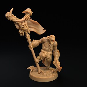May include: A brown plastic miniature figurine of an Orc warrior holding a staff with a skull and a banner. The Orc is wearing a loincloth and has a fierce expression on its face.