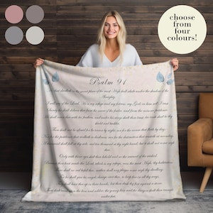 May include: A white fleece blanket with a vintage-style design featuring Psalm 91 from the Bible. The text is printed in blue and the background is a light beige with a subtle watercolor effect.