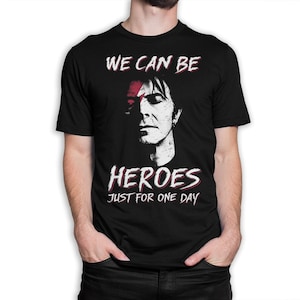 May include: Black t-shirt with a white graphic of a man's face and the text "We can be heroes just for one day".