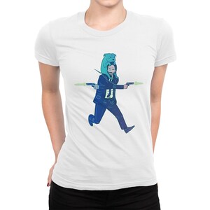 May include: A white t-shirt with a blue and green illustration of a man running with a dog on his head. The man is holding two guns and the dog is wearing a blue bandana.