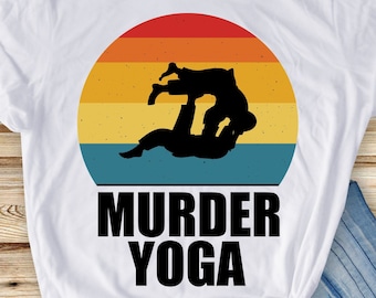 Peut inclure: T-shirt blanc avec un graphique de coucher de soleil rétro et le texte "Murder Yoga". Le graphique représente deux personnages en position de lutte.