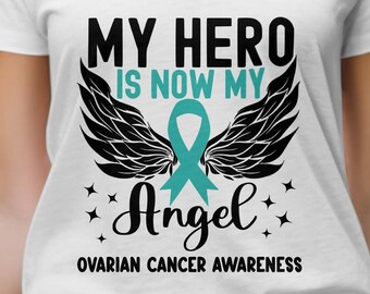 Może przedstawiać: Biała koszulka z dekoltem w kształcie litery V z napisem "My Hero is Now My Angel" i turkusową wstążką z czarnymi skrzydłami. Pod wzorem znajduje się napis "Ovarian Cancer Awareness".