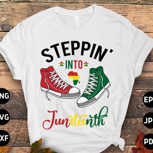 May include: White t-shirt with the text "Steppin' into Juneteenth" in black and yellow lettering. The shirt features a red and green sneaker on each side with a small yellow star and a red, yellow, and green African continent graphic.