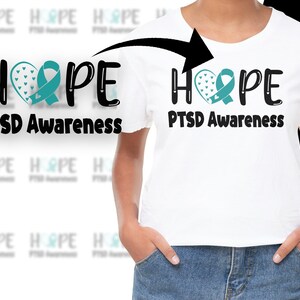 May include: White t-shirt with a black graphic that says "HOPE" with a teal ribbon heart and the text "PTSD Awareness" underneath.