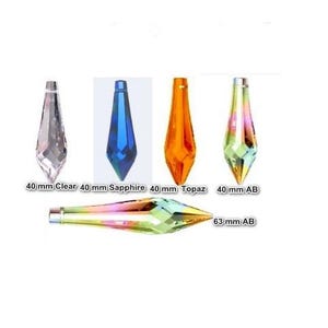 May include: Five faceted crystal pendants in a teardrop shape. Four vertical pendants measure 40 mm in clear, sapphire, topaz, and AB finishes. One horizontal pendant measures 63 mm in an AB finish. Each piece features a top metal loop.