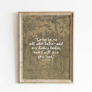 May include: A framed print with a vintage aesthetic. The artwork features a detailed illustration of a forest scene in shades of brown and beige. White text reads, "Come to me all who labor and are heavy laden, and I will give you rest."
