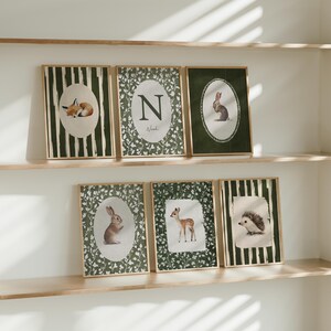 May include: Set of six framed art prints featuring woodland animals. Each print has a different animal: a fox, rabbit, deer, and hedgehog. The prints have a green and white color scheme with a wooden frame.