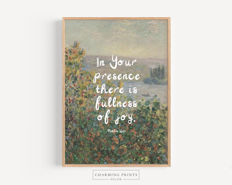 May include: A framed art print featuring a landscape painting with a quote in white script: "In Your presence there is fullness of joy." The artwork has a light brown wooden frame and a floral and landscape background.