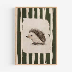May include: A framed print featuring a watercolor illustration of a hedgehog. The hedgehog is depicted in soft, muted tones with a spiky back. The background has vertical green and white stripes, and the frame is a natural wood color.