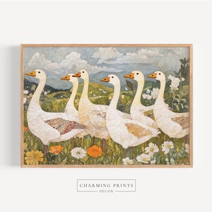 May include: A framed print featuring six white geese with orange beaks and accents, standing in a field of wildflowers. The background shows a landscape with rolling hills, a cloudy sky, and a few birds. The print is labeled "Charming Prints Decor."