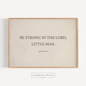 May include: A beige framed print with the text "Be strong in the Lord, little man. Ephesians 6:10" in black font.