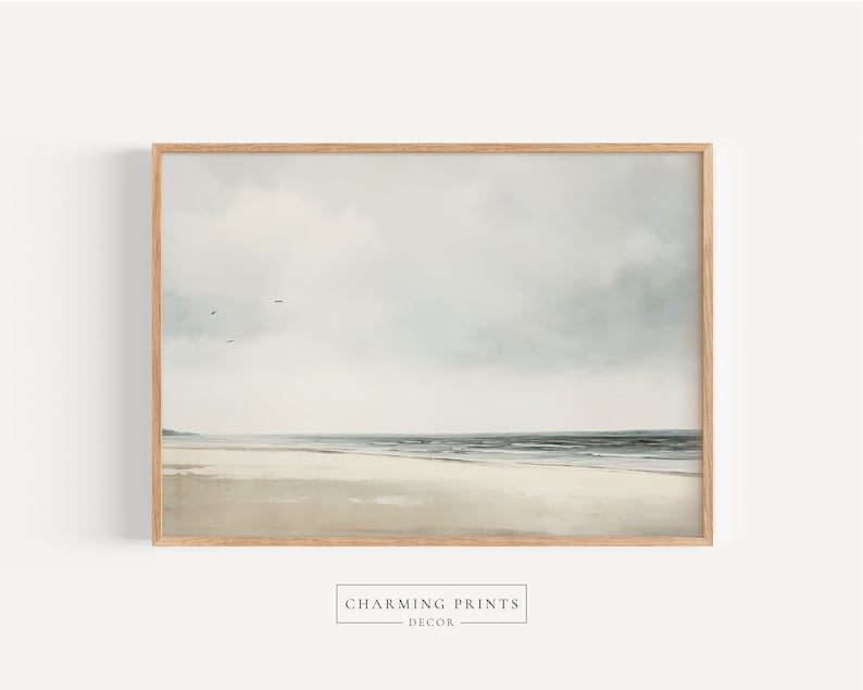May include: A framed print of a seascape painting. The painting depicts a calm ocean with a sandy beach in the foreground. The sky is a light blue with white clouds.