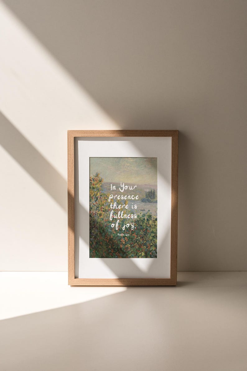 May include: Framed art print featuring a landscape painting with the text "In Your presence there is fullness of joy." The artwork is set in a light brown wooden frame with a white mat. The print has a soft, natural color palette.