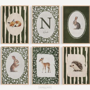 May include: Six framed art prints featuring woodland animals. The prints include a fox, rabbit, deer, and hedgehog, each within an oval frame. The backgrounds vary, with some having green foliage or striped patterns. The frames are a light wood color.
