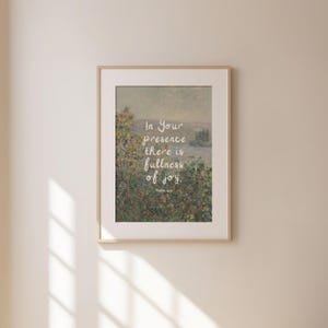 May include: Framed art print featuring a landscape painting with a soft, muted color palette. The artwork includes the text "In Your presence there is fullness of joy." The frame is a light wood color.