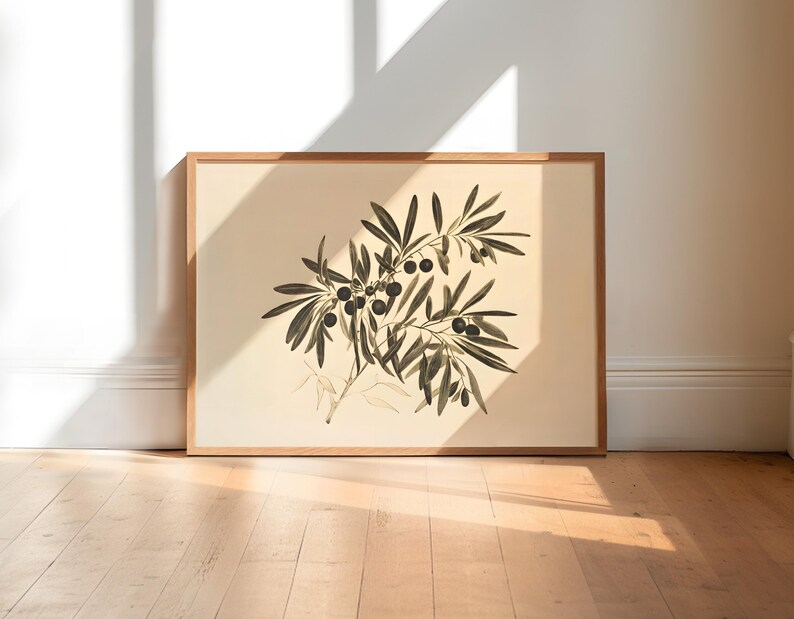 May include: A framed botanical illustration of an olive branch with green leaves and black olives. The print is on a cream background and is framed in a light wood frame.