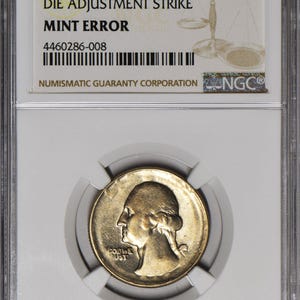 May include: A 1965 25-cent coin with a die adjustment strike mint error, encapsulated in a protective case. The coin features a profile of George Washington. The case includes the text "The Real Thing!"
