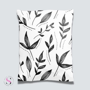 Könnte beinhalten: Weißer Kissenbezug mit einem schwarz-weißen Blumenmuster. Das Muster zeigt stilisierte Blätter und Stängel.