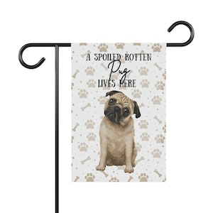 May include: A white garden flag with a brown pug dog illustration and the text "A Spoiled Rotten Pug Lives Here". The background is a light blue with brown paw prints and bone patterns.
