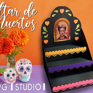 Pode incluir: Um altar preto em camadas com um retrato de Frida Kahlo, bordas decorativas laranja, roxas e rosas e detalhes de coração. O altar é colocado em um fundo laranja com flores de calêndula e caveiras de açúcar.