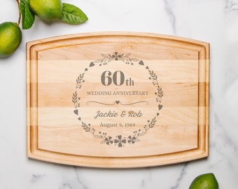 May include: A wooden cutting board with a curved edge, engraved with "60th Wedding Anniversary", "Jackie & Rob", and "August 9, 1964".