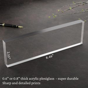 May include: A clear acrylic plaque measuring 21.5 cm by 6.5 cm. The plaque is 1.5 or 2 cm thick and made of durable plexiglass.  Sharp and detailed prints.