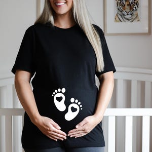 Funny maternity t-shirt with baby feet - perfect for baby bump photos. T-shirt with baby feet for expecting mothers. Pregnancy outfit.