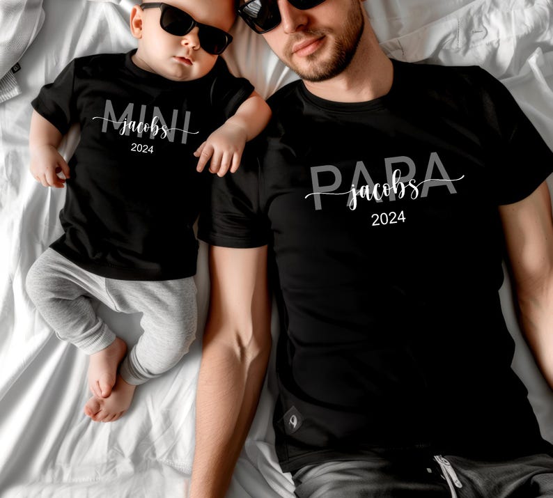 May include: A black t-shirt with the text "PARA jacobs 2024" and a smaller black t-shirt with the text "MINI jacobs 2024".