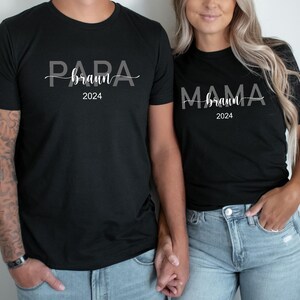 May include: Two black t-shirts with white text. The first shirt says "Papa Braun 2024" and the second shirt says "Mama Braun 2024".