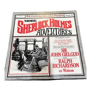 May include: A vintage vinyl record album titled "More Sherlock Holmes Adventures." The cover features a red and white title, illustrations of Sherlock Holmes and Watson, and the names of the actors Sir John Gielgud and Ralph Richardson.