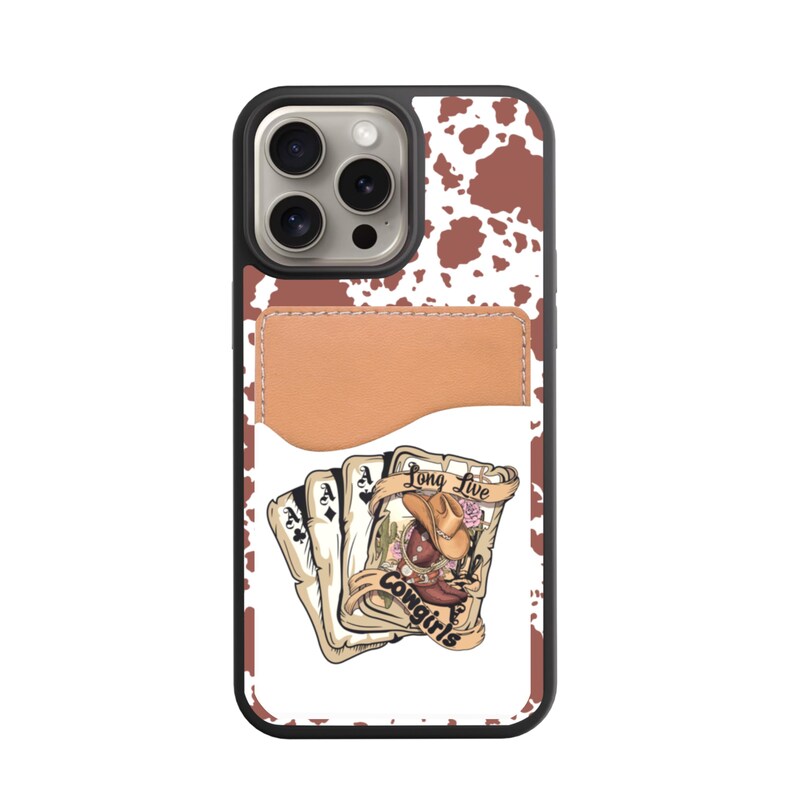May include: A black phone case with a brown and white cowhide pattern. The case features a brown leather card holder and a graphic of playing cards with a cowgirl illustration and the text "Long Live Cowgirls."
