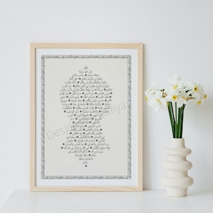 Op de afbeelding: Een ingelijste print van een zwart-wit islamitisch kalligrafieontwerp in Arabisch schrift. Het ontwerp heeft de vorm van een boom met het woord "Allah" bovenaan. De print is op een crèmekleurige achtergrond.