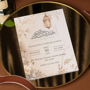 May include: An invitation to an Eid Mubarak lunch on Monday, May 2, 2023 at 8 PM. The invitation features a delicate floral design with a hanging lantern and Arabic calligraphy. The event will be held at 203 Mahopac Avenue, Granite Springs, NY 10527. RSVP to 123-456-7890.
