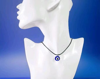 Puede incluir: Un collar de cordón negro con un colgante azul de ojo turco. El colgante es redondo y tiene un centro blanco.