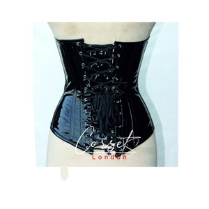 May include: Black patent leather corset with a lace-up back. The corset has a boned structure and a smooth, shiny finish. The corset is labelled "Corset London".